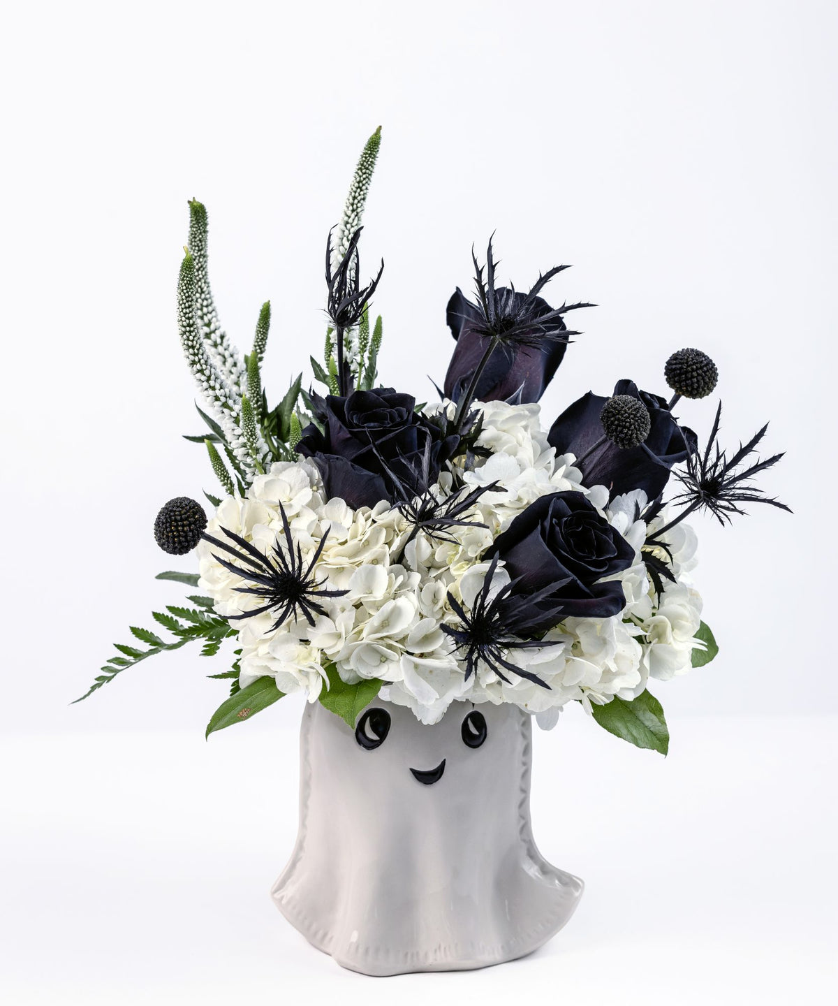 Halloween floral arrangement with black roses and white hydrangea in a white ghost ceramic vase
