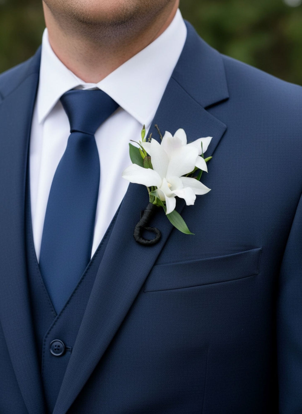 White and purple dendrobium orchid boutonniere with greenery and ribbon