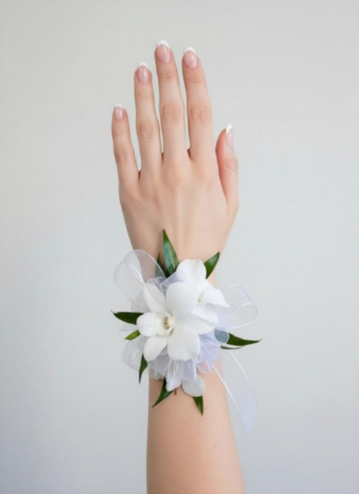 Dendrobium orchid corsage with delicate blooms, greenery, and matching ribbon