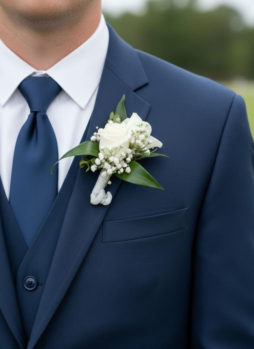 Double spray rose boutonniere with greenery and coordinating ribbon