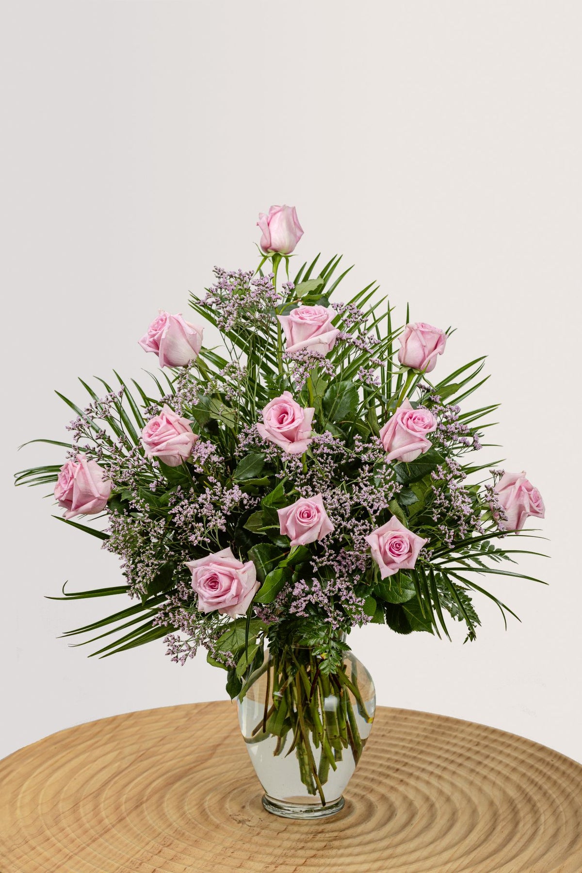 One dozen ultimate pink roses with greenery.