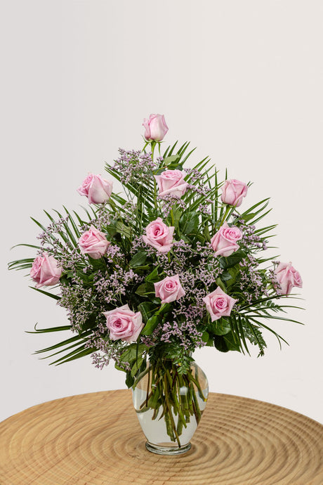 One dozen ultimate pink roses with greenery.